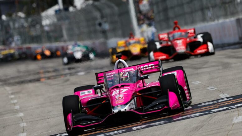 A Long Beach arriva la prima vittoria in INDYCAR Series per Kyle Kirkwood, autore di una prestazione a dir poco maiuscola in uno dei Gran Premi più difficili dell’anno. Il 22enne di Jupiter, Florida, si sblocca al secondo anno nella categoria, il primo in Andretti Autosport, regalando al team di Michael la settima vittoria nelle stradine di Long Beach, nonché la prima stagionale. Il tutto precedendo Romain Grosjean, in coda a Kirkwood per tutto l’ultimo terzo di gara e, ancora una volta, a pochi passi dal primo successo in INDYCAR. Oltre alla doppietta firmata Andretti, il podio del terzo round lascia spazio anche a Chip Ganassi con Marcus Ericsson, terzo classificato al termine di un Gran Premio in cui ha rischiato di riportare danni importanti nel contatto con la Dallara di Pato O’Ward, finito contro il muro di gomme di curva 8 dopo un incidente con il poi vincitore Kyle Kirkwood, uscito indenne dall’episodio. Nonostante il contatto tra le ali anteriori di Ericsson e O’Ward, lo svedese non ha riportato danni rimontando furiosamente fino al terzo posto, conquistato grazie ad un bel sorpasso su Colton Herta, quarto a fine gara. E per Andretti Autosport la quarta posizione di Herta rappresenta il miglior modo per chiudere un fine settimana straordinario, nel quale le tre punte del team sono riuscite ad entrare in Top5, chiusa da un Alex Palou risalito fino al quinto posto in una gara tiratissima. Dunque, Chip Ganassi Racing si è distinto come unico team a mettere i bastoni tra le ruote ad Andretti, sebbene l'assenza di Dixon non si possa trascurare. "Iceman", infatti, è sparito dai radar dopo essere stato accompagnato verso il muro di gomme da O'Ward in curva otto (giro 20), ripartendo dal fondo della classifica e, successivamente, rientrando definitivamente ai box per un problema idraulico. Gara in chiaroscuro anche per il Team Penske, al sesto posto con Will Power, autore di una corsa molto solida, al nono con Josef Newgarden ed al decimo con Scott McLaughlin. Se quest'ultimo non ha brillato nello stint centrale con le gomme morbide, per Newgarden si è trattato sicuramente di un ottimo risultato cestinato a causa del risparmio carburante. Un vero peccato per il due volte campione INDYCAR, l’unico in grado di tenere in vita per circa trenta giri gli pneumatici morbidi. Per via della caution del giro 20 (contatto Dixon-O'Ward) la prima sosta è stata anticipata di cinque/sei passaggi, costringendo tutti i piloti, chi più chi meno, ad una gara improntata sul risparmio del bioetanolo. E dopo aver percorso parecchi giri in testa alla gara, dimostrandosi perfetto nel gestire le gomme morbide, Newgarden si è dovuto piegare ad una tattica conservativa, perdendo posizioni su posizioni nell'ultimo stint del GP e salendo in nona posizione solo grazie all'incidente di Rossi (Arrow McLaren), a muro nel penultimo giro. A proposito di McLaren, alla fine del Gran Premio l'unico che può accennare un timido sorriso è Felix Rosenqvist, settimo alle spalle di Will Power e davanti al rookie Marcus Armstrong, molto bravo ad amministrare gomme e carburante in un appuntamento così delicato. Come detto, Rossi è finito a muro a due giri dalla fine (curva 9), perdendo i punti di un sesto posto che sarebbe stato più che dignitoso essendo partito undicesimo. O'Ward, invece, ha sofferto le conseguenze del contatto con Kirkwood, transitando sotto la bandiera a scacchi in diciassettesima posizione. Ciò significa che O'Ward ha perso il primo posto in classifica a favore di Ericsson, ora in testa con 110 punti, quindici in più di O'Ward. Diciannove le lunghezze di ritardo per Palou, terzo, seguito a due punti da Josef Newgarden. Con la vittoria di Long Beach Kyle Kirkwood ha guadagnato la quinta posizione in campionato, a -36 da Marcus Ericsson. Prossimo appuntamento della NTT INDYCAR Series il 30 aprile nel circuito permanente di Barber, Alabama.